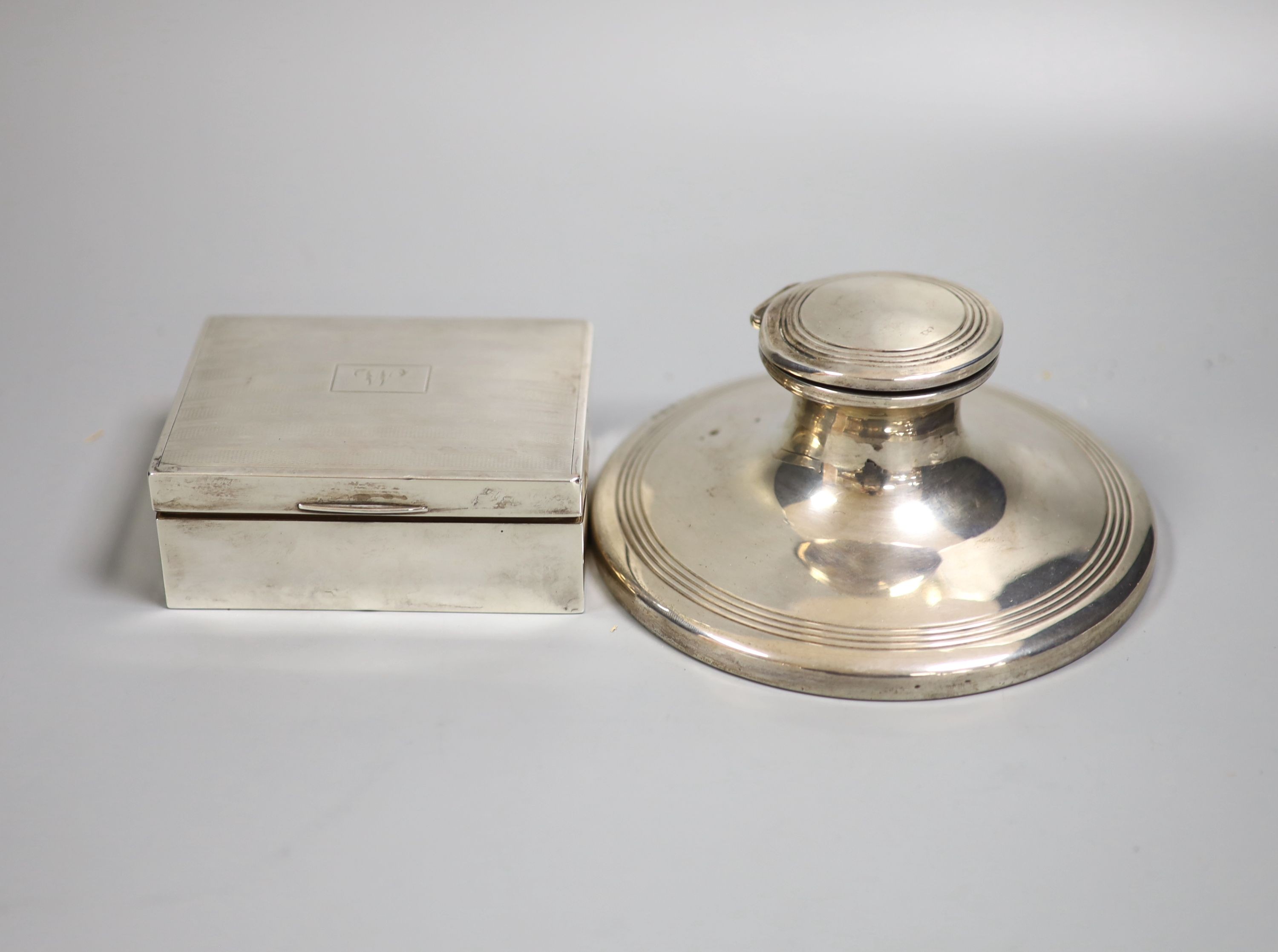 A George V silver mounted capstan inkwell, 15.2cmm weighted and a silver mounted cigarette box.